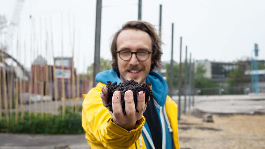 Enno hält einen Haufen Erde in der Hand