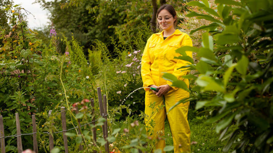 Tanja hält Gartenschlauch vor sich