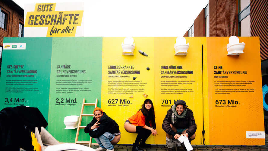 Menschen vor Plakaten zur Sanitärkrise